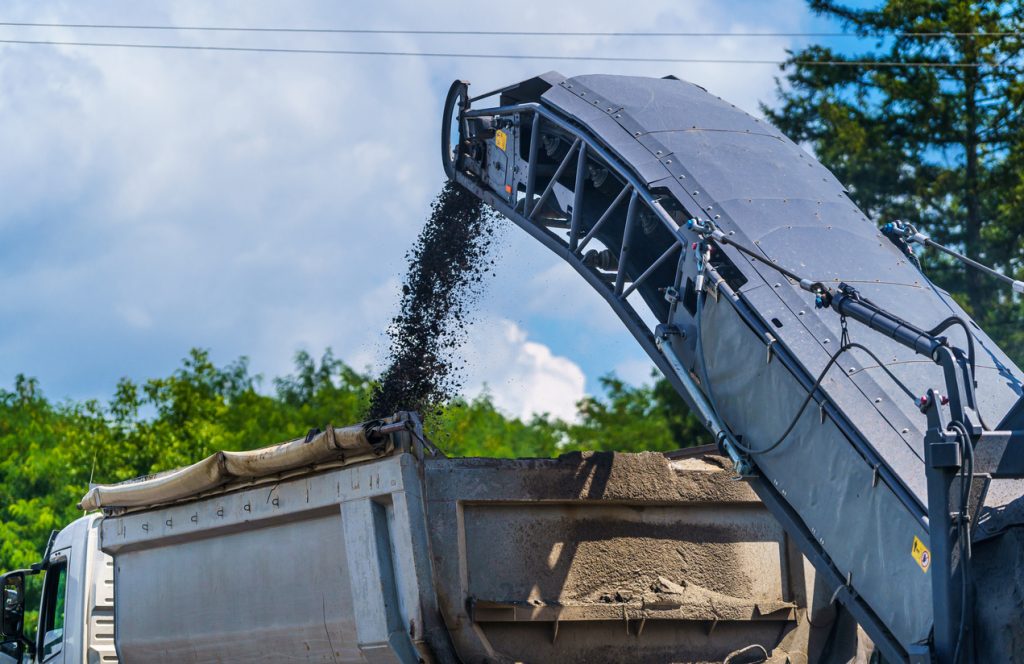 Kierrätysmateriaalia kaadetaan ajolava-ajoneuvoon.